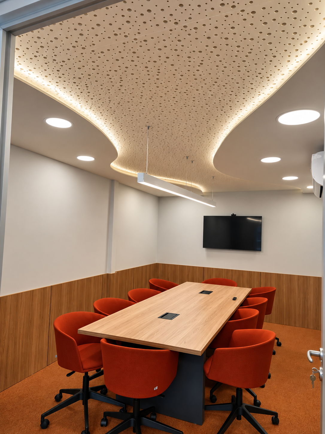 Sala de reuniões com mesa de madeira e poltronas